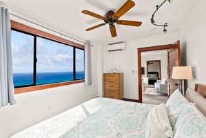 Bedroom with a cozy queen-sized bed and breathtaking ocean views from the large window.
