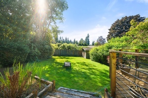 A vibrant backyard oasis with a manicured lawn, perfect for relaxing or playing games.