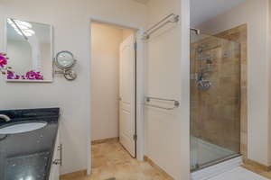 A walk-in shower in a glass enclosure.