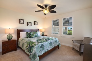 Spacious guest bedroom with tropical-inspired decor, a ceiling fan, and its own full ensuite bath.