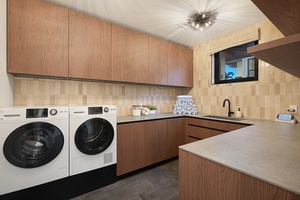 Spacious laundry room with full-size washer and dryer, generous cabinetry, and counter space for extended island stays.