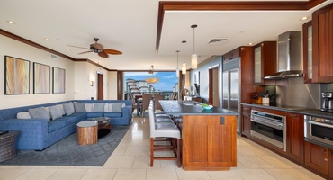 Step into your stunning open-plan living space where rich wood tones meet ocean blues, creating the perfect backdrop for your Hawaiian getaway.