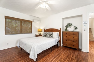 Unwind in your peaceful bedroom with crisp linens, warm wood furnishings, and natural light filtering through bamboo blinds.