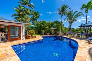 Dive into the inviting waters of the pool, adorned with shimmering blue tiles.