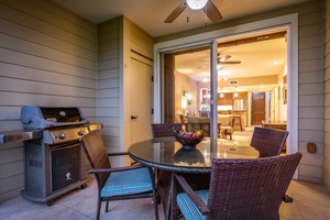 Outdoor dining space on the lanai at twilight with view into the condo.