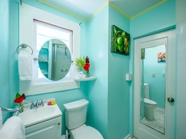 Refresh in your bright turquoise bathroom featuring tropical touches and thoughtful amenities for your comfort.