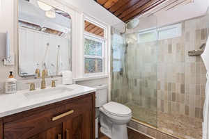 Indulge in your private spa-inspired bathroom with a luxurious walk-in shower, elegant marble countertops, and warm wood accents.