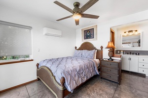 Additional guest bedroom with queen bed, ceiling fan, and split A/C for restful nights.