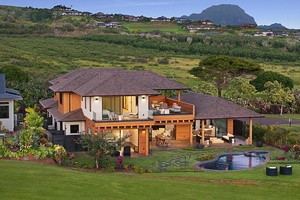 Modern luxury estate with private pool nestled in lush tropical landscaping and a scenic mountain backdrop.