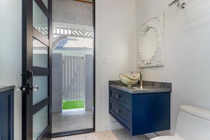 Powder room with stylish vanity and direct exterior access for pool convenience.