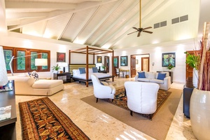 Spacious primary bedroom with a plush bed and ample seating.