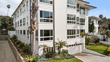 Beautifully maintained building exterior surrounded by lush coastal landscaping. Welcome home!