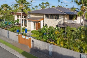 The beautifully landscaped entrance highlights the home’s modern elegance and island charm.