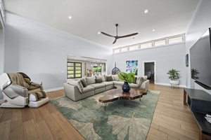 Sunlit great room with large sectional, Smart TV, and serene views—perfect for gathering with family and friends.