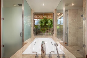 Primary bath soaking tub with view to courtyard w/tropical landscaping.