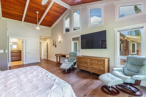 The Lani Oasis primary suite includes vaulted ceilings, a flat-screen TV, and cozy lounge seating for private comfort.