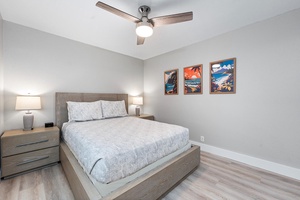 Upstairs bedroom #1 featuring a queen bed and island-themed artwork.