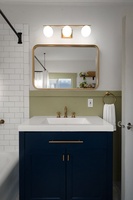 Refresh with ease in this bright bathroom featuring brass accents and subway tile details.