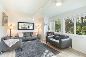 Bright, welcoming & comfortable living room with large windows and garden views—perfect for relaxing after beach days.