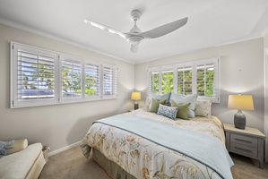 The second guest suite has a plush king bed, soft linens, natural light, and island-inspired decor, creating the perfect Hawaiian retreat.