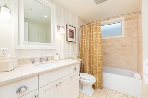 Spacious guest bathroom with double vanities, glass shower, and modern design.