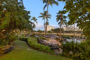 A tranquil garden oasis with towering palms framing a serene pool area, inviting relaxation amidst lush greenery.