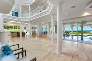 Grand open layout with soaring ceilings, columns, and polished tile flooring creates a sense of luxury on arrival.