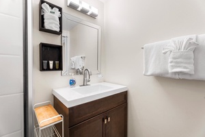 Step into your thoughtfully designed bathroom with modern vanity, premium amenities, and plush towels waiting for your arrival.