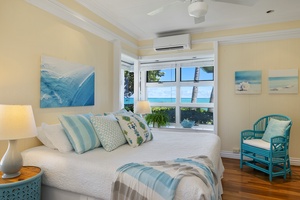 The primary bedroom has views of the beach and ocean, a king bed, and ensuite bath