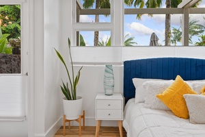 A calm bedroom corner featuring a modern white nightstand with two drawers.