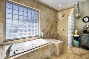 Large soaking tub and walk-in shower can be found in the Primary suite