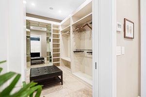 Designer closet with elegant shelving and full-length mirror.