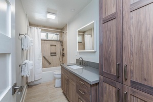 The guest bathroom with a single vanity and shower/tub combo.