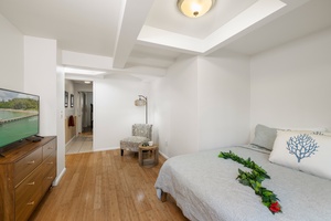 Simple and serene, this private guest suite features soft tones, a comfortable queen bed, and direct access to shared bath amenities.