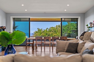 Custom dining table with seating for 8, overlooking lush greenery and ocean views.