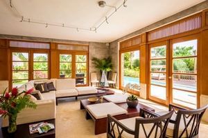 Gather in the bright living area leading to the pool and garden.