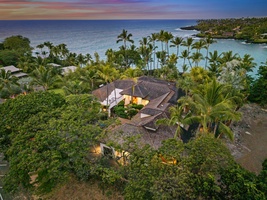 Stunning tropical paradise with dramatic sunset colors painting the sky above this secluded beachfront retreat surrounded by lush palms and pristine waters.