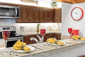 The fully equipped kitchen features granite counters, quality appliances, and elegant table settings for memorable meals.
