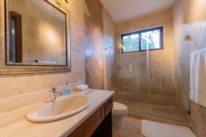 Ensuite bathroom with a spacious walk-in shower and elegant stone finishes.