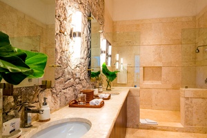 The full ensuite bathroom's interior with a stone accent wall.