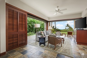 Retreat room with flat screen television, desk, plush seating and lanai.