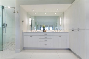 Bright double vanity space with ample storage and full-wall mirrors.