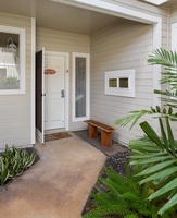 The welcoming front entrance is surrounded by lush tropical landscaping.