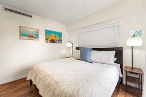 Drift off to sleep surrounded by ocean-inspired art in your peaceful bedroom, where soft linens and warm wood floors create the perfect retreat.