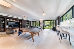Enjoy friendly competition in this spacious game room equipped with a ping-pong table and bar seating.