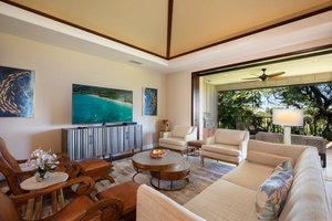 Here, a spacious living area with a sprawling TV set and plush sofas offers the perfect setting for relaxation or social gatherings.