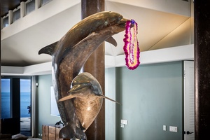 Admire this stunning dolphin sculpture adorned with tropical leis, bringing coastal charm to your luxury getaway.