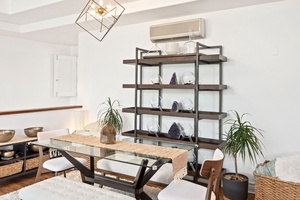 A sleek glass dining table with matching chairs and bench seating invites guests to gather.