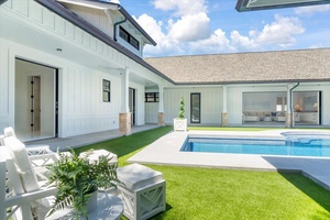 Courtyard-style design surrounding the pool creates seamless indoor-outdoor living.
