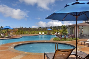 Relax and refresh in the community pool and hot tub, surrounded by lush tropical landscaping.
